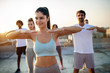 © NDABCREATIVITY - Group of fit healthy friends, people exercising together outdoor on rooftop