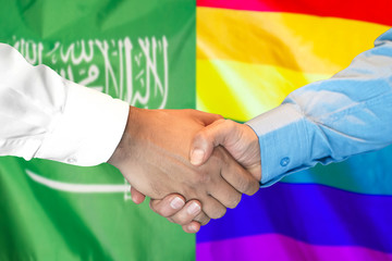 Business handshake on the background of two flags. Men handshake on the background of the Saudi Arabia and LGBT gay flag. Support concept