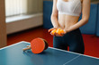 Young woman holds ping pong balls