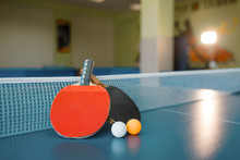 Two Ping Pong Paddles On The Table With Net