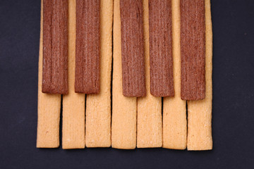 Wall Mural - Light and dark, black and white fitness cookies with fiber laid out in the form of piano keys. Nutrition harmony concept