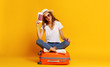 © JenkoAtaman - concept of travel. happy woman girl with suitcase and  passport on  yellow background.