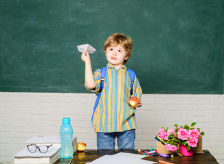 back to school and happy time. origami lesson in school. little boy play with paper airplane. child 
