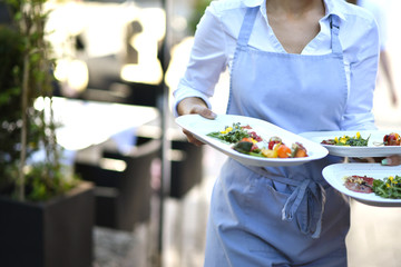 Bedienung serviert Essen für die Gäste im Restaurant