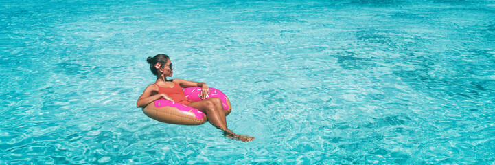 Wall Mural - Vacation beach banner woman relaxing on donut inflatable float ring swimming in turquoise ocean water panoramic. Summer travel sun lifestyle.