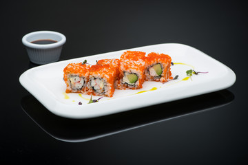 sushi in a plate on a black background with reflection. fish roll