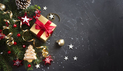Wall Mural - christmas dark black background with beautiful texture and golden gift box with red ribbon, fir bran