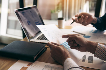 Two business partnership coworkers and gesturing with discussing a financial planning graph and company during a budget meeting in office room.