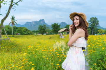woman in yellow cosmos flower field