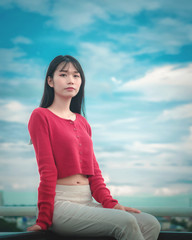 portrait Asian woman wearing casual red long-sleeved t-shirt in park.