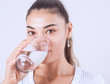 © izzetugutmen - Young woman drinking glass of water