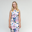 Portrait of a pretty beautiful adult female 35 years old blonde on a white background in a light dress with a pattern. Standing in front of the camera, smiling.
