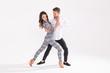 © satura_ - Social dance concept - Active happy adults dancing bachata or salsa together over white background with copy space