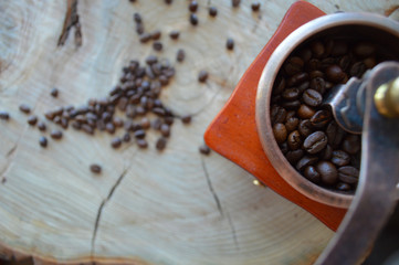  Manual coffee grinder on a wooden, light background with coffee beans