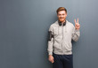 © Asier - Young fitness redhead man fun and happy doing a gesture of victory