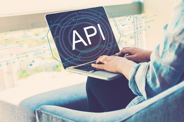 api concept with woman using her laptop in her home office