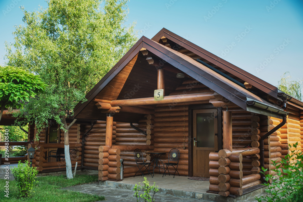 Wooden cottages with log and paved with wild stone paths on the ...