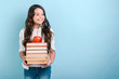 © speed300 - Portrait of smiling nerd young girl holding stack of books with apple on it. Back to school. - Copyspace