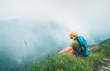 Wall Mural - backpacker man has a rest break enjoying cloudy valley bottom walking by the foggy cloudy weather mo