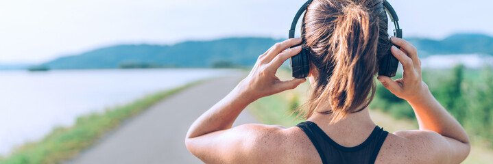 young teenager girl adjusting wireless headphones before starting jogging and listening to music. we