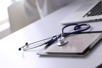 Wall Mural - Medical equipment: blue stethoscope and tablet on white background. Medical equipment