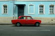© Sergey Chumakov - red retro car near blue retro building on street