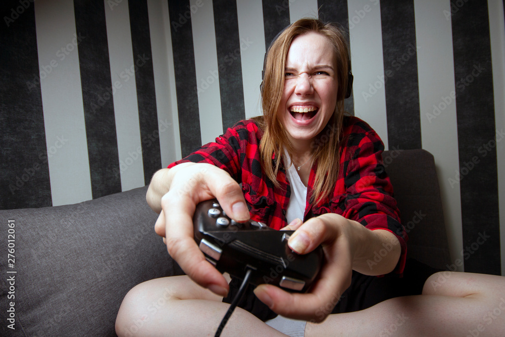 Young aggressive girl plays computer games on the joystick at night in ...