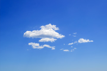 Wall Mural - Scenic group of white fluffy cumulus clouds high in the blue summer sky. Different cloud types and atmospheric phenomena. Skyscape.