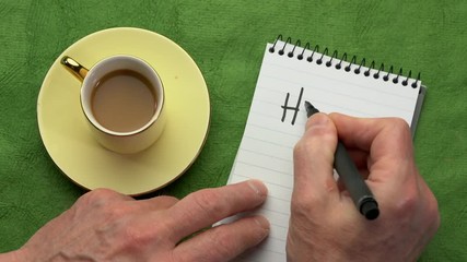 Canvas Print - hygge, danish lifestyle concept - man hand writing in a notebook, overhead view