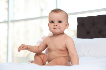 Poster - Cute baby in diaper on bed at home