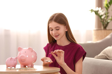 Poster - Teen girl with piggy banks and money at home