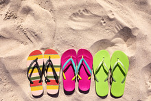 Flat Lay Composition With Flip Flops On Sand In Summer, Space For Text. Beach Accessories
