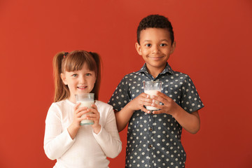 Wall Mural - Cute little children with glasses of milk on color background