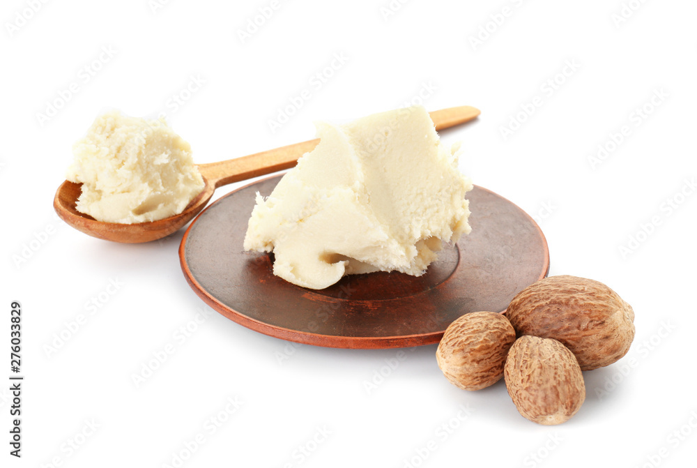 Plate and spoon with shea butter on white background