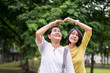 © gballgiggs - Take care and support concept,Portrait of elderly asian woman with daughter posture hand heart at outdoor together,Elderly health insurance