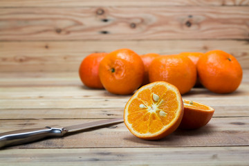 Wall Mural - Close up Orange fruit on wooden table with knife