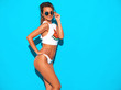 © halayalex - Portrait of young beautiful sexy smiling hipster woman in white summer underpants and topic.Trendy girl in in sunglasses. Positive female going crazy.Funny model isolated on blue