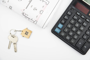 Buying a house, building repair and mortgage concept. Estimation real estate property with loan money and banking. Plan of a house, keys and calculator on white background isolated. 