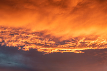 Wall Mural - Dramatic orange sky with clouds at sunset. It can be used as a background