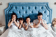 © Тарас Нагирняк - Family of four has a flue and lying on bed together in the morning.