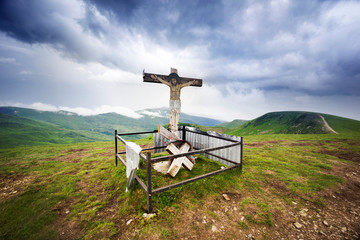 cross and clouds in the mountains at sunrise