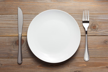 Poster - plate, knife and fork at wooden  background