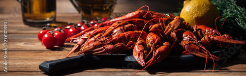 Cuadros en Lienzo panoramic shot of red lobsters, tomatoes, dill, lemon and glasses with beer on w