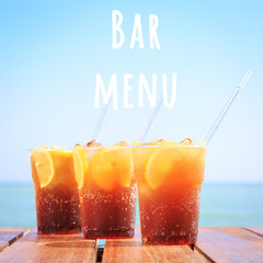 Wall Mural - Concept of luxury tropical vacation. Cuba Libre or long island iced tea cocktail on the pier. Beach party. Clear blue sky. Square. Bar menu wording