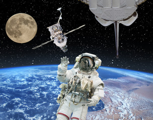 Astronaut in outer space, moon and spaceships on the backdrop. The elements of this image furnished by NASA.