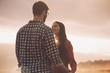 © StockPhotoPro - Young loving couple holding hands at sunset