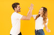 © Drobot Dean - Portrait of caucasian couple man and woman in basic t-shirts rejoicing while giving high five together