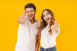 © Drobot Dean - Portrait of brunette couple man and woman in basic t-shirts rejoicing and showing thumbs up at camera