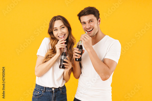 Fotomural Portrait of content couple man and woman in basic t-shirts standing together whi
