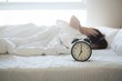 © BoszyArtis - Woman sleep on the bed turns off the alarm clock wake up at the morning, Selective focus.